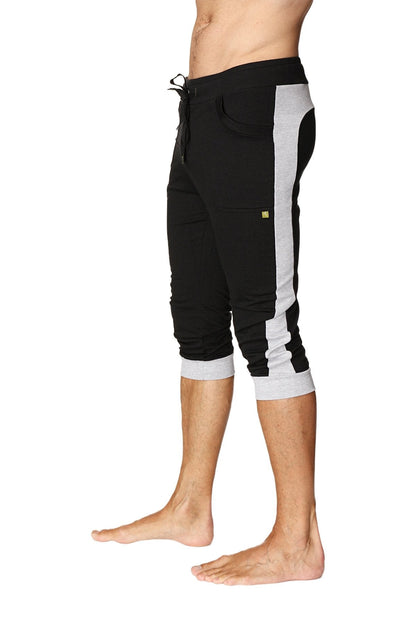 Cuffed yoga pants in black with grey side stripes featuring a drawstring waist and rolled cuffs for athletic wear