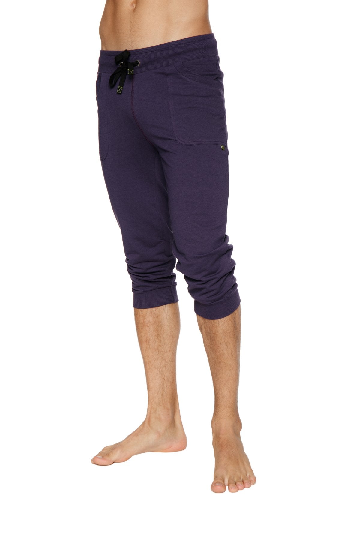 Cuffed yoga pants in eggplant purple with a black drawstring waistband and side pockets made from soft fabric