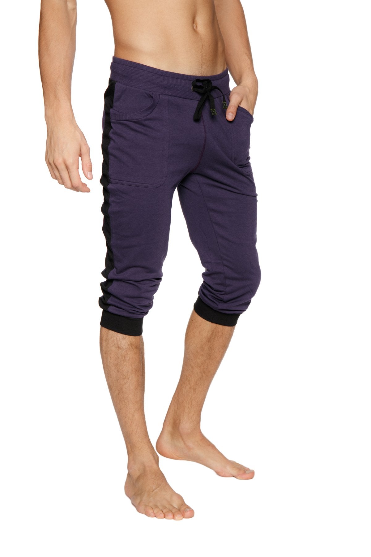 Purple cuffed yoga pants with black side panels elastic cuffs and capri-length design for comfortable workouts