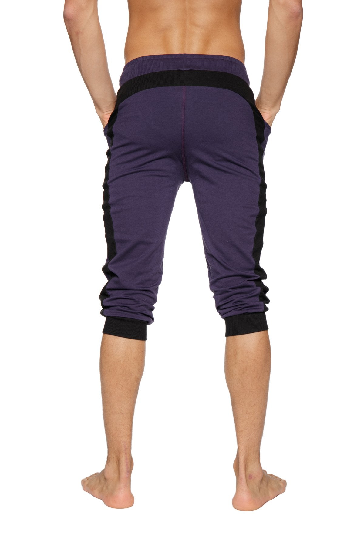 Purple cuffed yoga pants with black side panels and elastic cuffs made from athletic fabric for active wear
