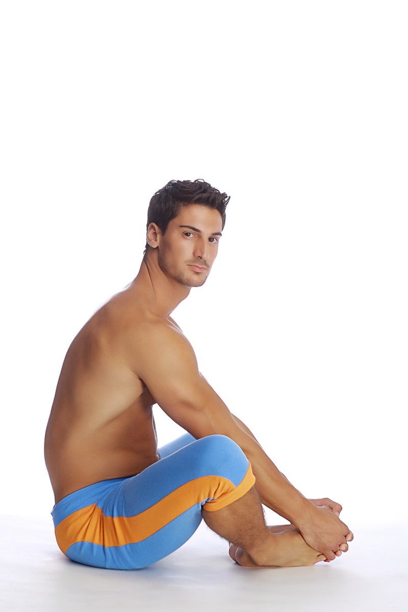 A man wearing cuffed yoga pants in ice blue with orange stripes designed for comfortable activewear sessions