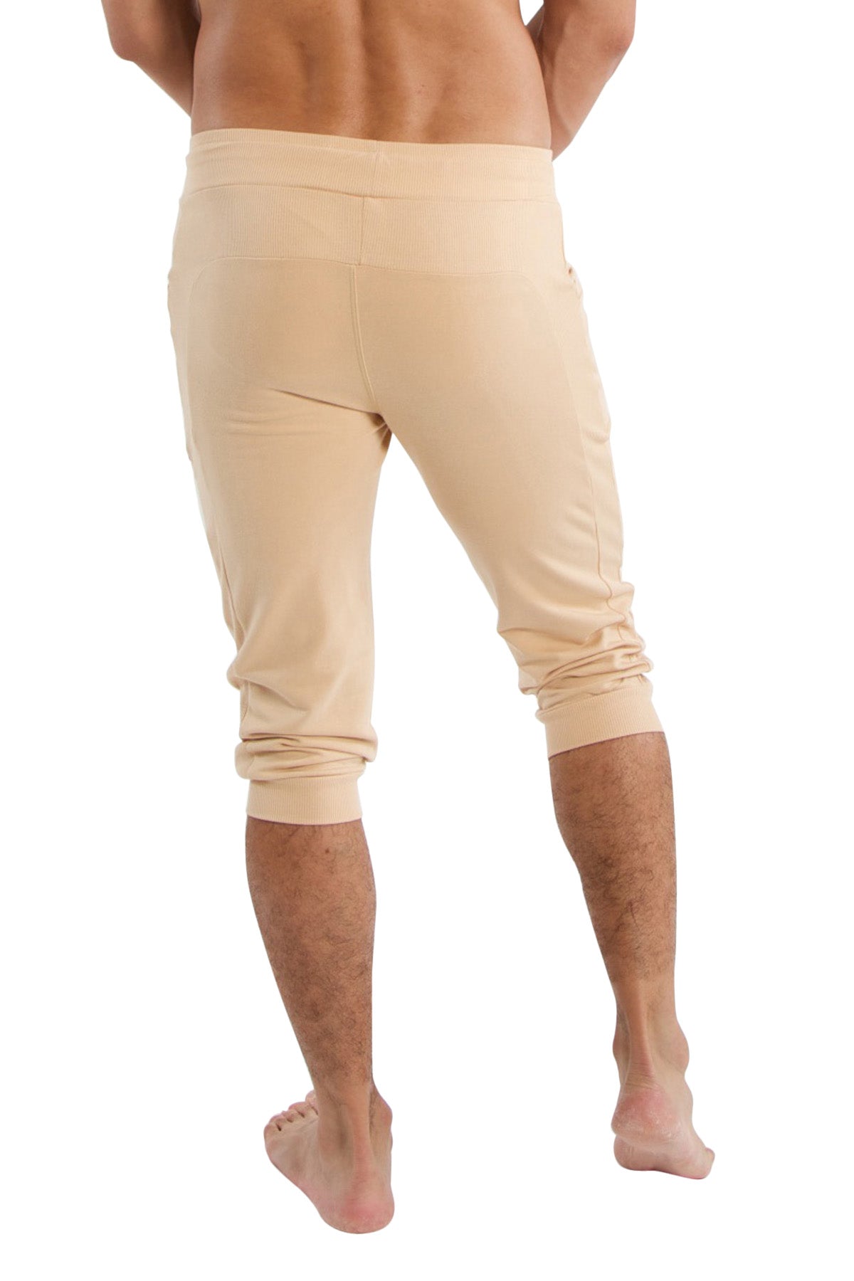 Beige cuffed yoga pants in soft stretchy fabric with rolled cuffs and capri length for comfortable athletic wear