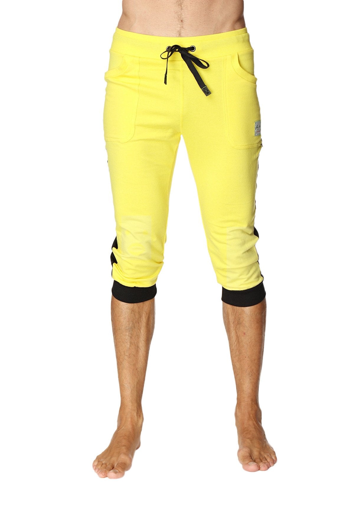 Bright yellow cuffed yoga pants with black drawstring waistband side pockets and elastic cuffs in capri length