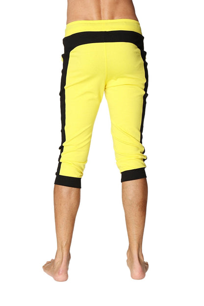 Cuffed yoga pants in tropic yellow with black side stripes featuring an elastic waistband and bright capri length