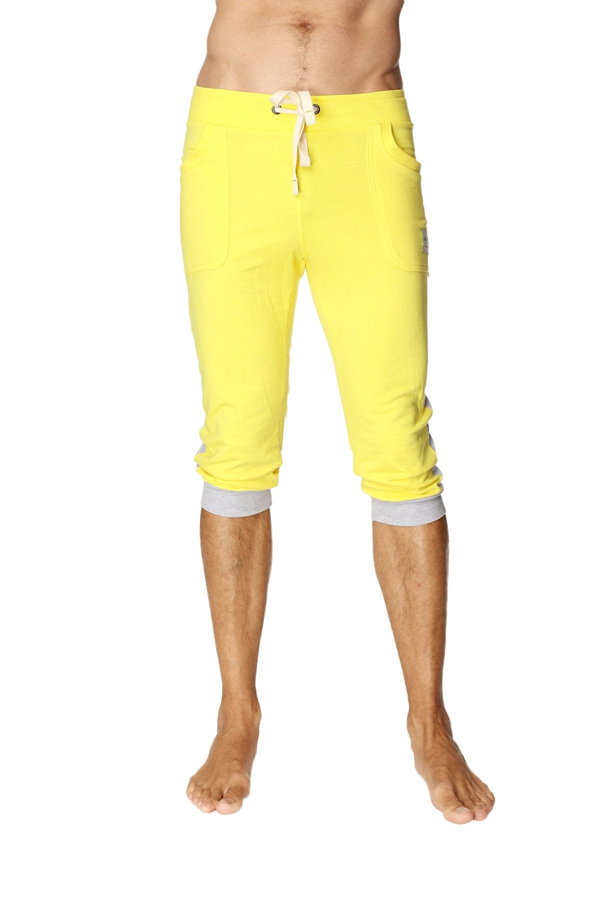 Bright yellow cuffed yoga pants with white drawstring and gray elastic cuffs in capri length for active wear