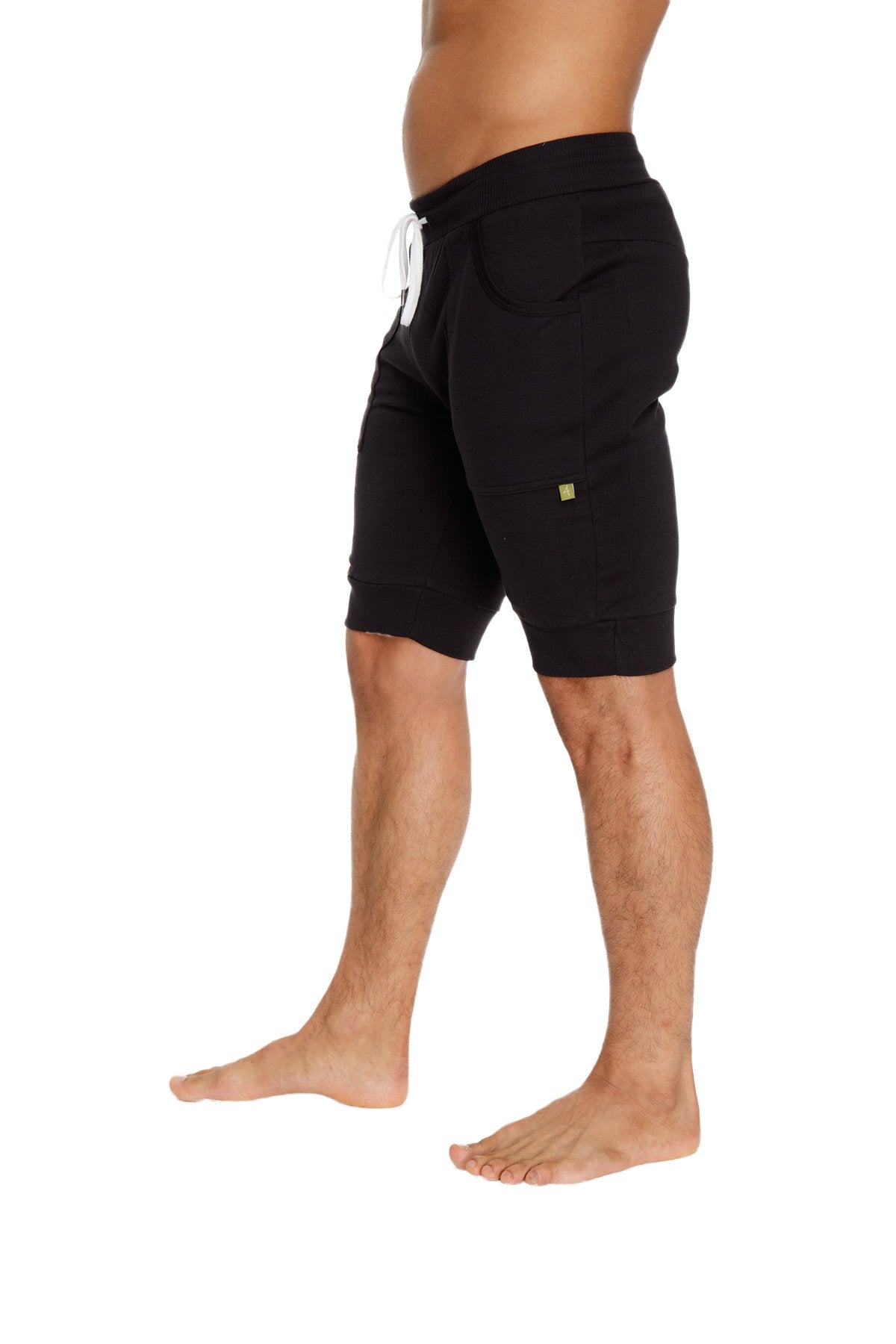 Black cuffed yoga shorts with white drawstring and small green logo ideal for comfortable activewear