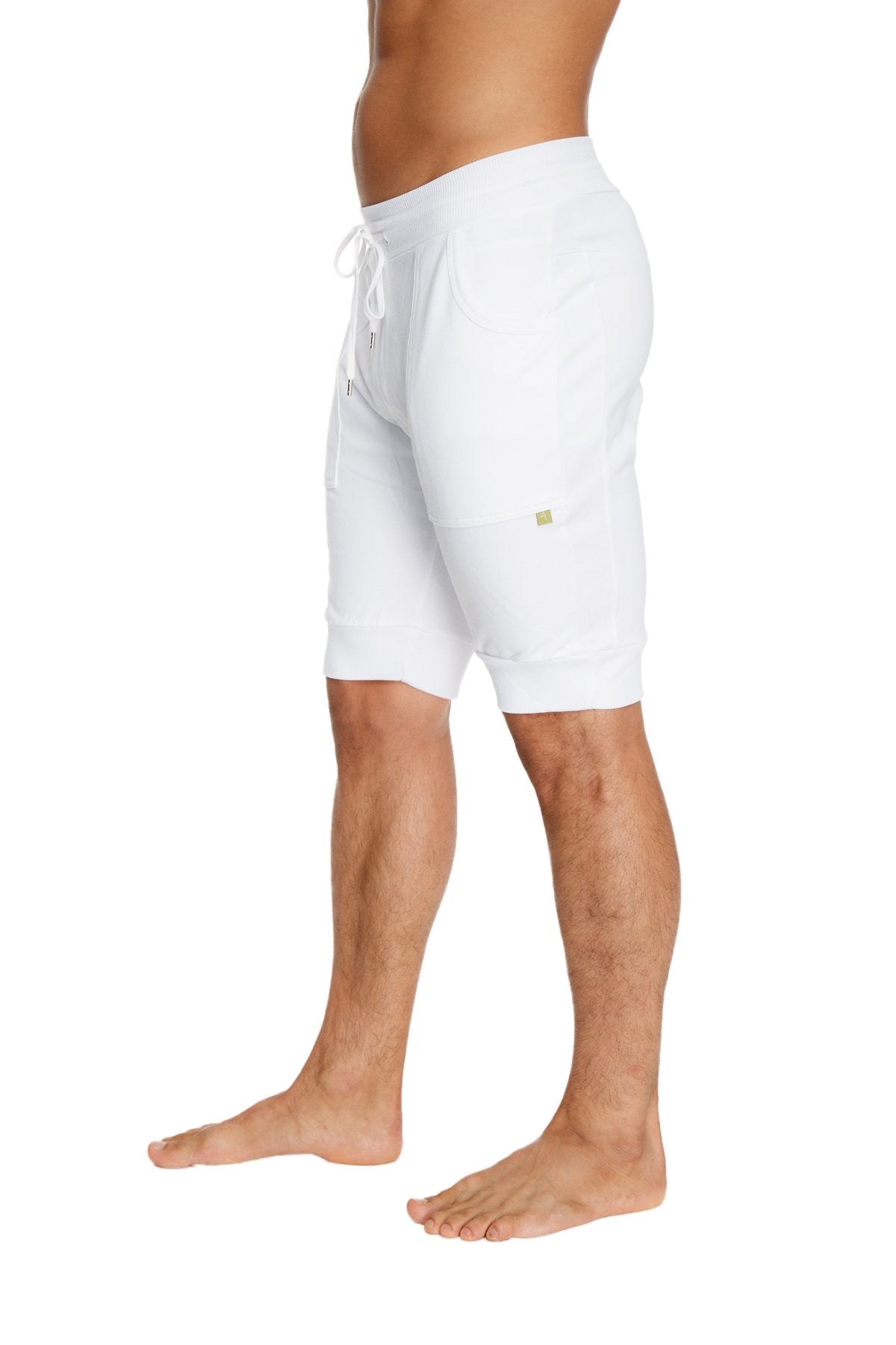 White cuffed yoga shorts with soft stretchy fabric and subtle green logo on the side