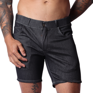 Front view of Gigo men’s black denim short with belt loops, fly button, and contrast stitching on a tattooed model.