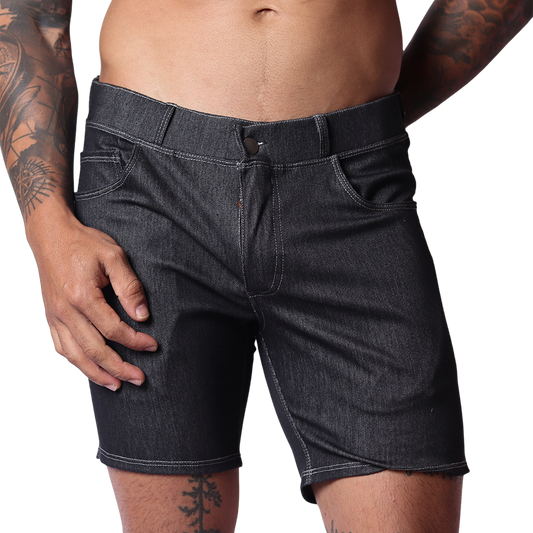 Front view of Gigo men’s black denim short with belt loops, fly button, and contrast stitching on a tattooed model.