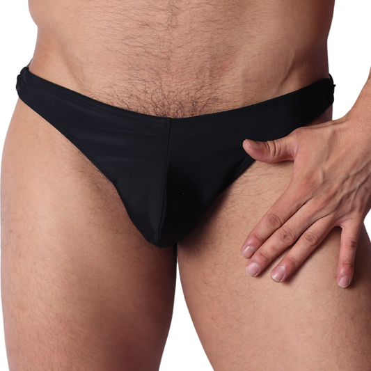 Front view of Gigo Dinamic black swim g-string in smooth, stretchy fabric with hand resting on hip.