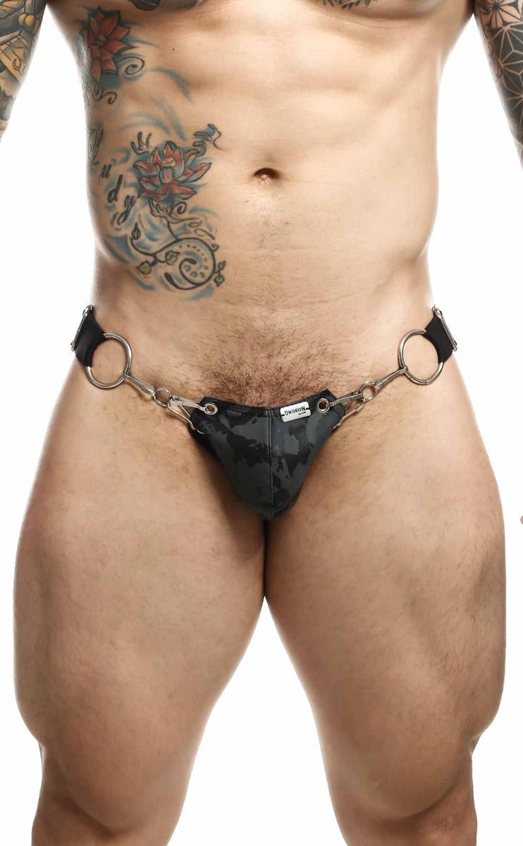 Black camouflage patterned thong with metal rings and leather straps shown from the back dngeon snap jockstrap