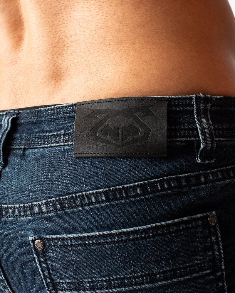 Black leather patch with embossed logo on the back of duke short dark blue denim jeans