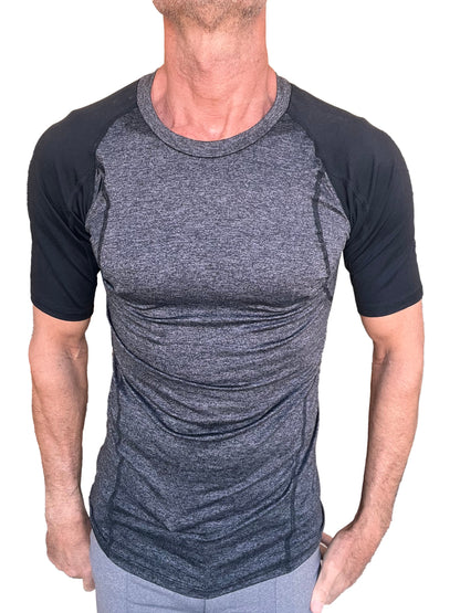 A men’s athletic crew-neck tee with charcoal heathered torso and black raglan sleeves with seam detailing