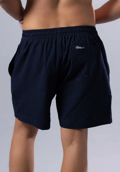 Image of the back side of dark navy blue essential swim short with elastic waistband and embroidered back pocket logo