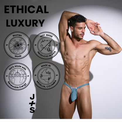 A teal men’s bulge thong mesh with form-fitting design and small brand tag at the front by Justin Simon
