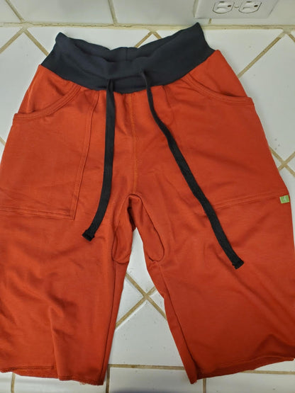 Eco-track short cinnabar orange athletic shorts with black elastic waistband drawstrings side pockets and green tag