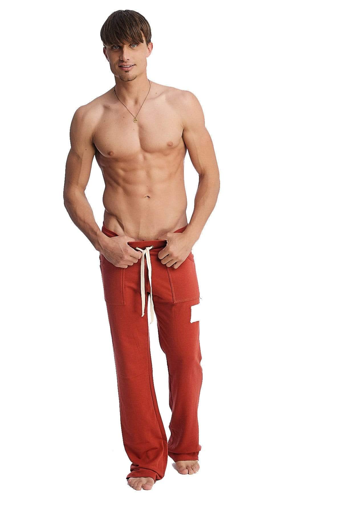 Edge eco-track and yoga sweat pant in cinnabar red with white drawstrings and a white patch on left thigh