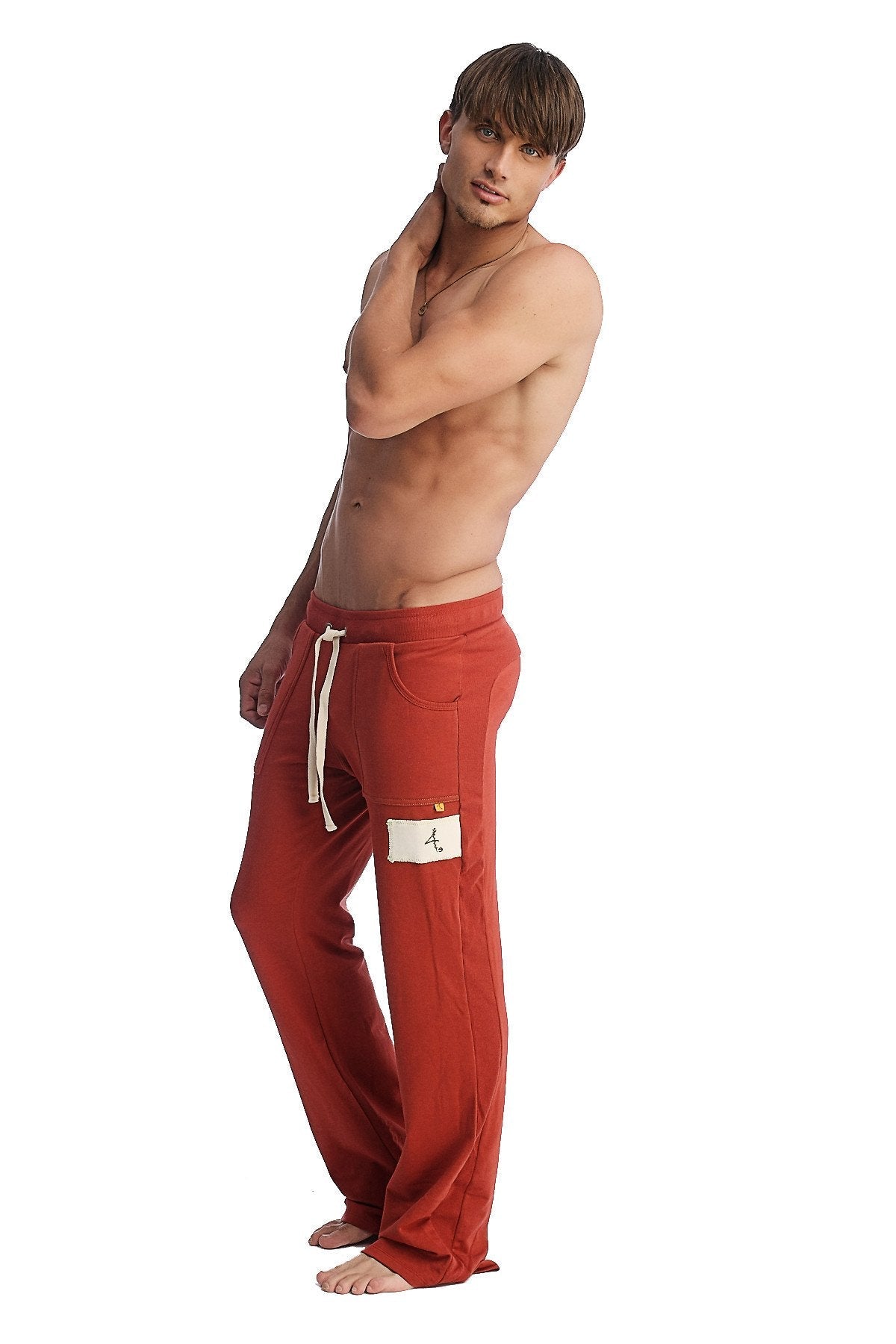 Red cotton edge eco-track and yoga sweat pant in cinnabar with white drawstrings and a patch on the left thigh