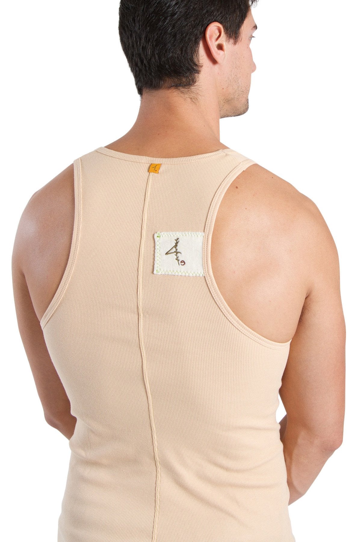 Back view of edge sustain tank top in sand beige ribbed cotton with central zipper and white label with black calligraphy