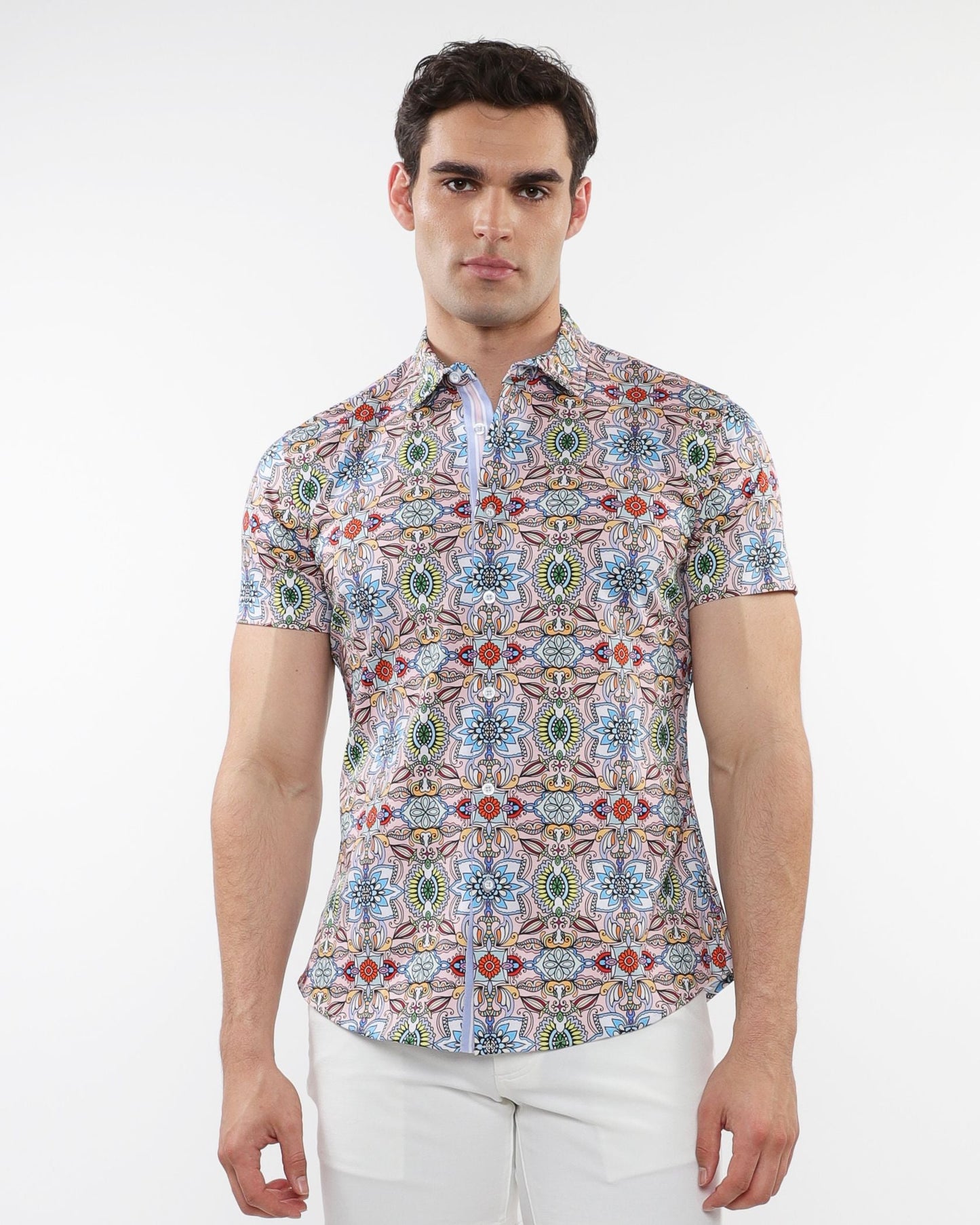 A man wearing a fauna print stretch knit short-sleeved shirt with colorful geometric patterns in blue green red and beige