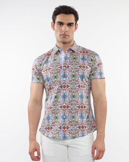 A man wearing a fauna print stretch knit short-sleeved shirt with colorful geometric patterns in blue green red and beige
