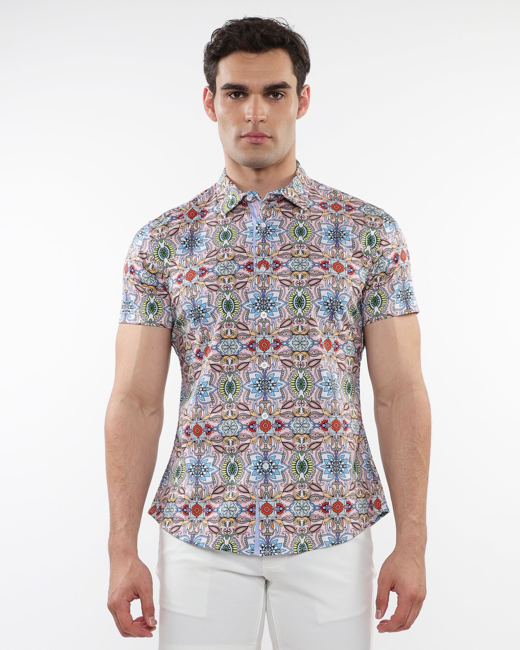 A man wearing a fauna print stretch knit short-sleeved shirt with colorful geometric patterns in blue green red and beige