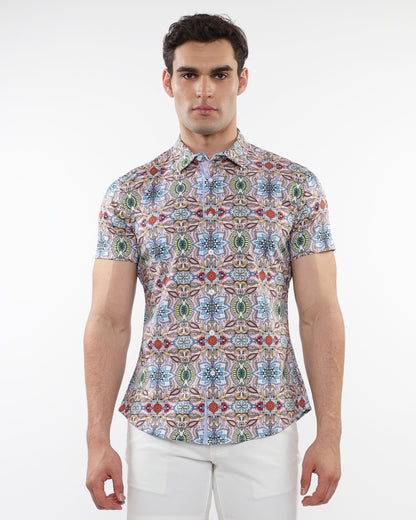 A man wearing a fauna print stretch knit short-sleeved shirt with colorful geometric patterns in blue green red and beige