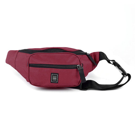 Maroon fanny pack with a black zipper, front pocket, square logo, and black strap.