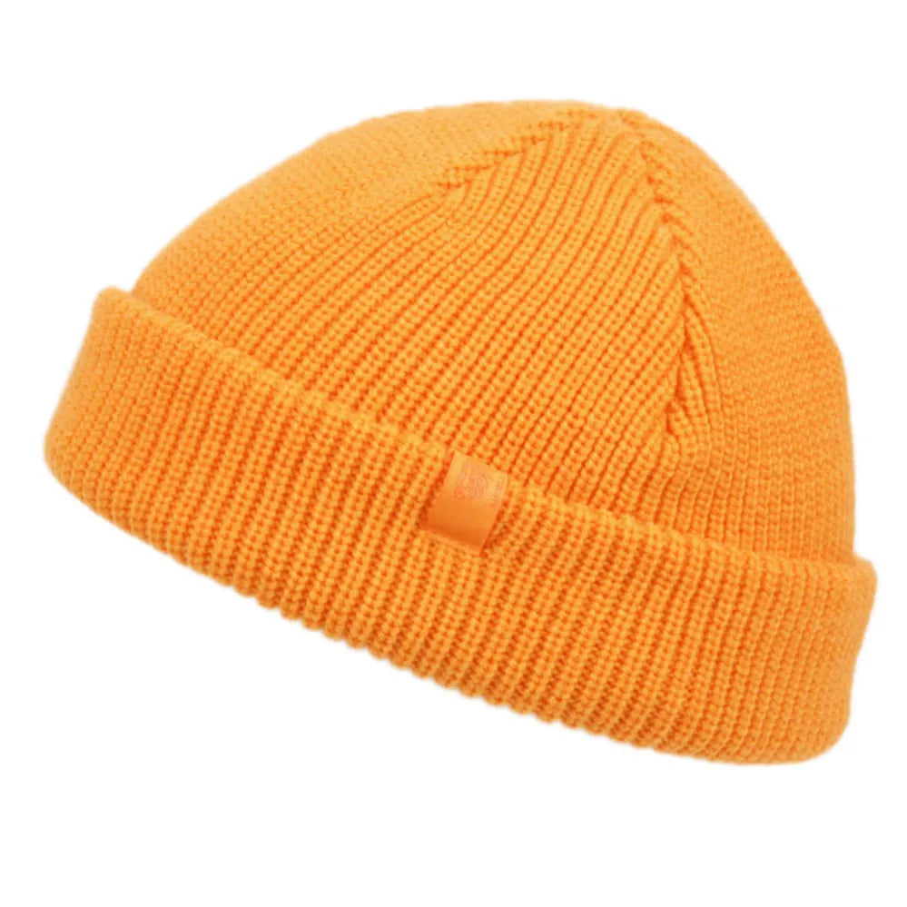 A vibrant orange fisherman dock knit cuff beanie with ribbed knit material and a folded cuff with a fabric tag