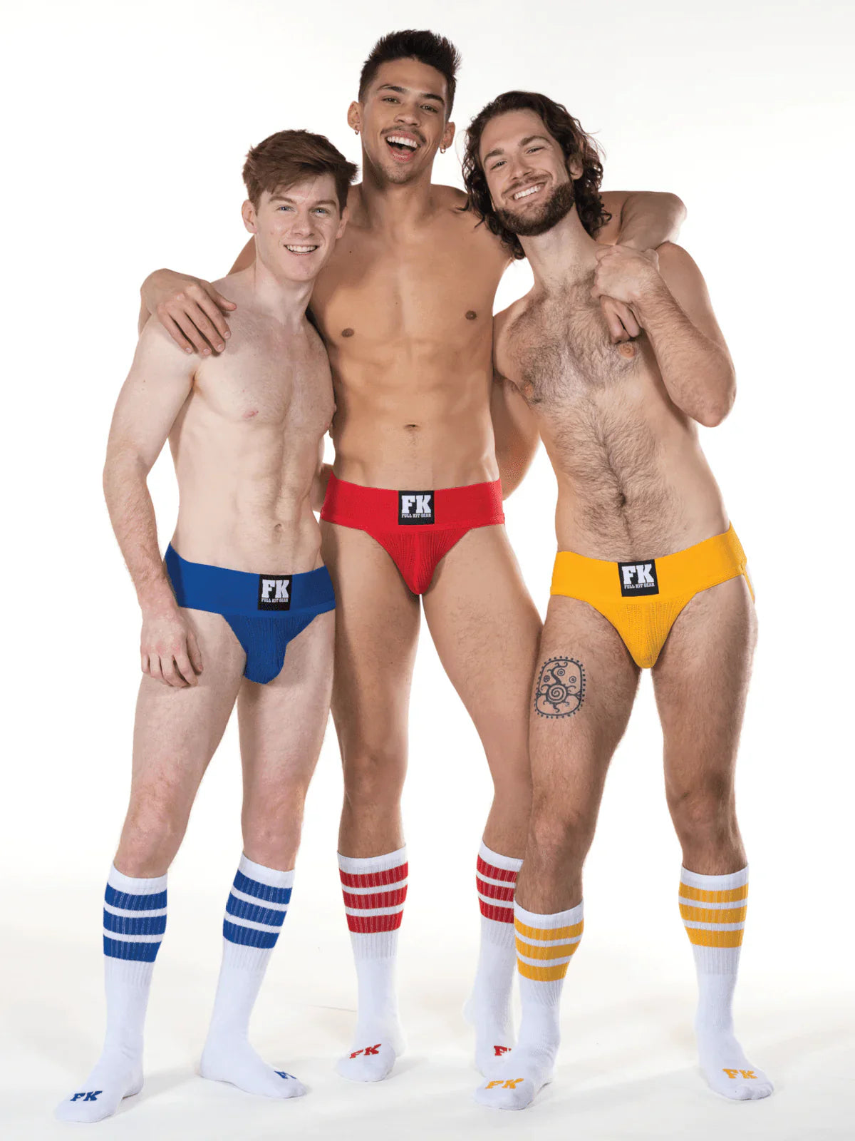 Three men wearing brightly colored low-rise briefs with black fk logo and white tube socks with matching stripes