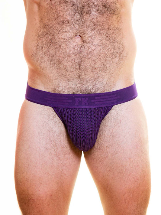 A person wearing a purple Full Kit jockstrap with a chevron-patterned mesh pouch and branded waistband.