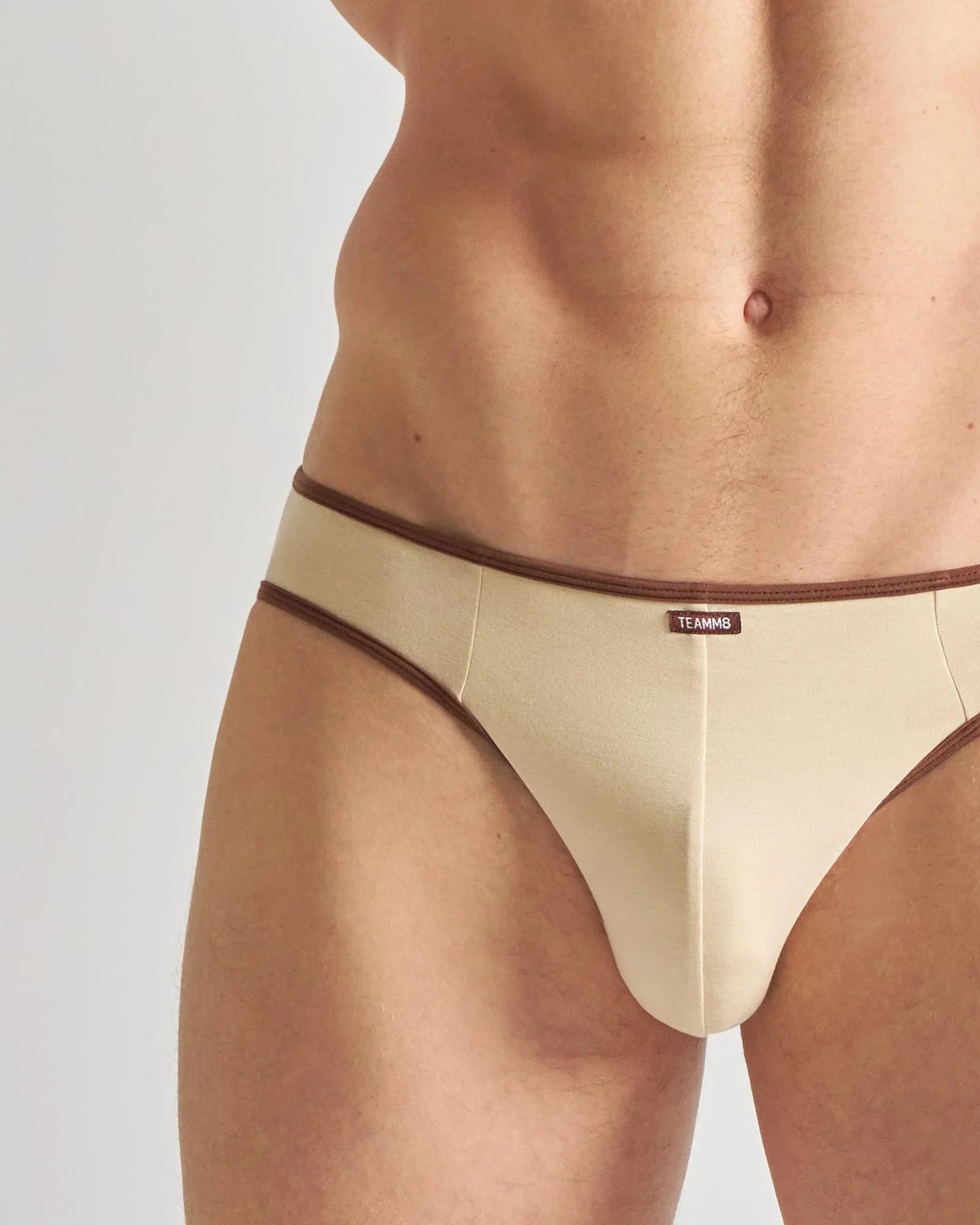 Beige team mg briefs with brown trim front view for flaunt jockstrap featuring breathable fabric and sporty design