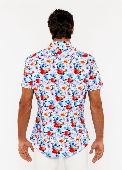 A vibrant floral 3d print stretch knit short-sleeved men’s shirt with red orange blue and purple blossoms on light blue