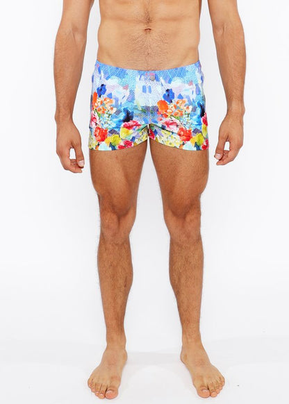 Floral abstract printed swim shorts with vibrant multicolored floral and castle print in blue red yellow and orange