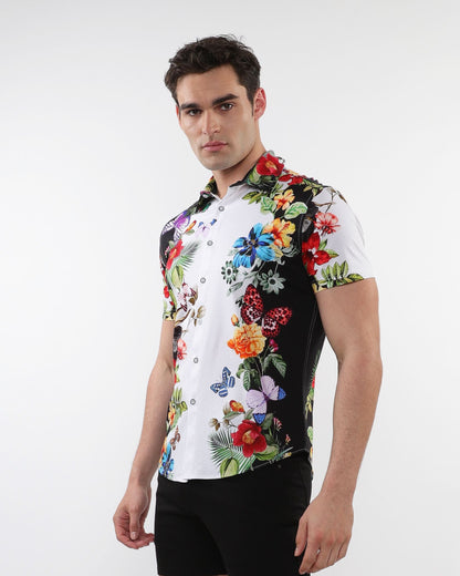 A vibrant short-sleeved floral border print stretch knit shirt with bold tropical flowers and butterflies on white and black background