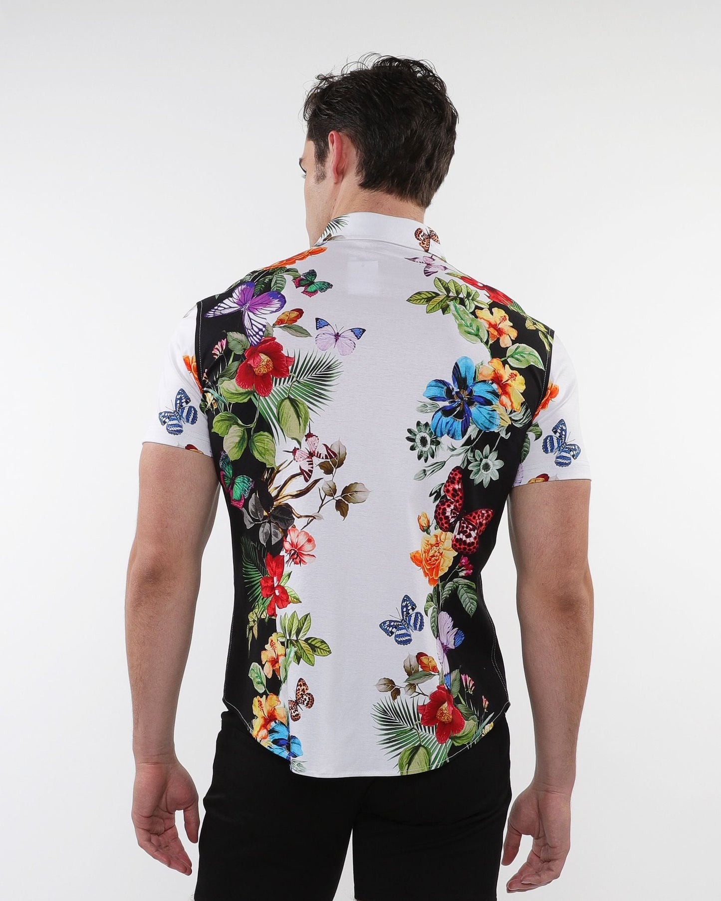 A vibrant floral border print stretch knit men’s shirt with bold butterfly designs in red blue purple and green on white