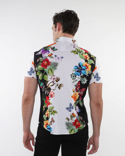 A vibrant floral border print stretch knit men’s shirt with bold butterfly designs in red blue purple and green on white