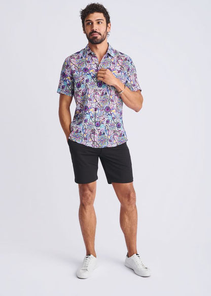 A man wearing a lightweight floral short-sleeved linen tencel shirt in purple, blue, and pink shades