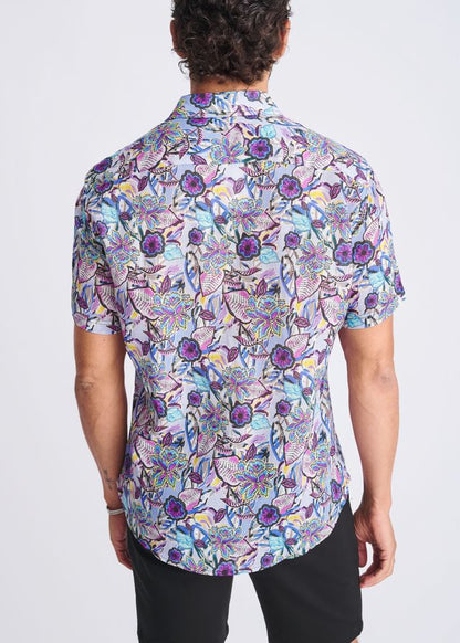 A floral lightweight linen tencel short-sleeved shirt with a vibrant purple blue and pink pattern on a light background