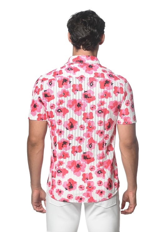 A man wearing a white floral print open knit shirt with vibrant pink flowers and subtle vertical stripes