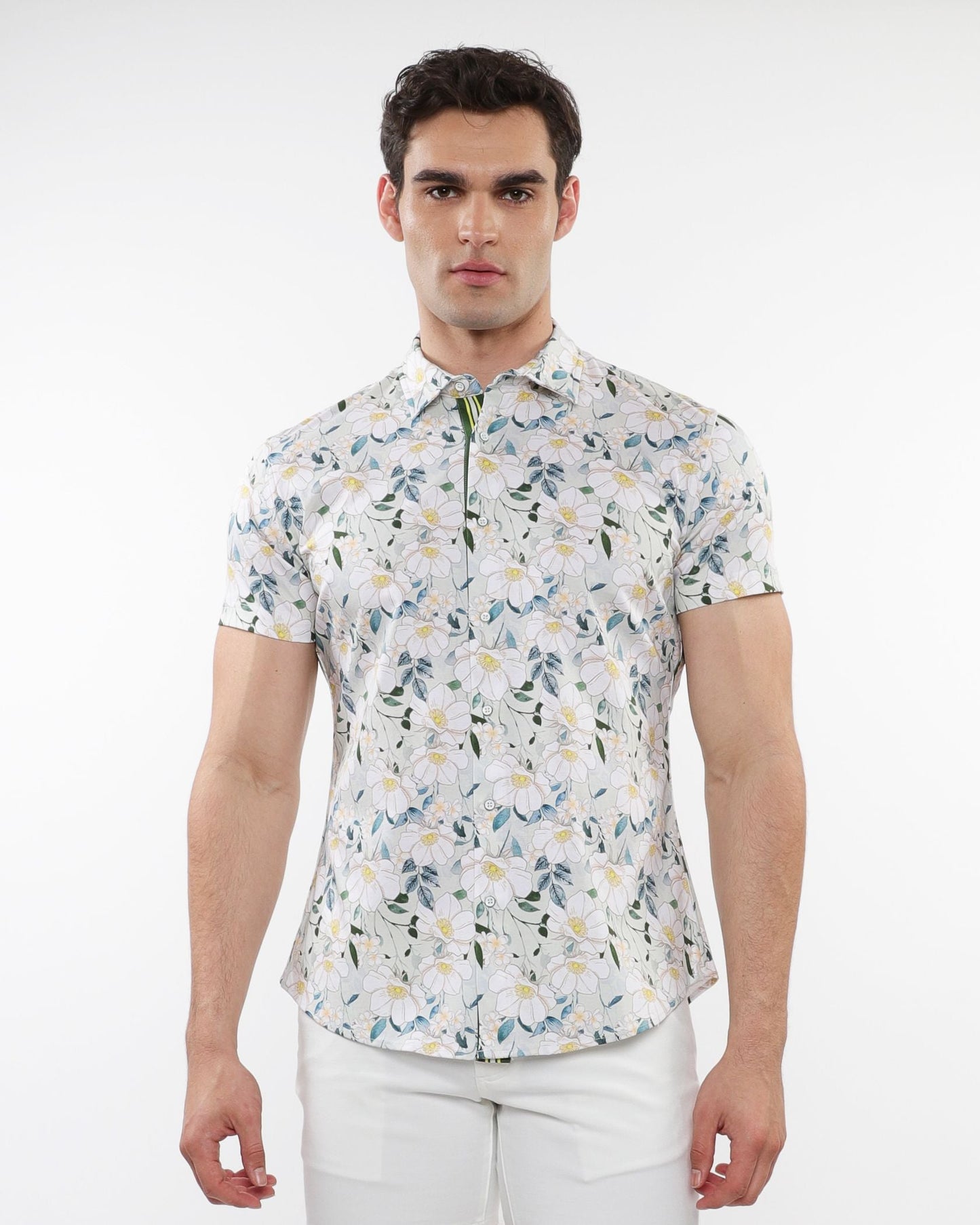 A man wearing a white floral print stretch knit short-sleeved shirt with green and yellow accents