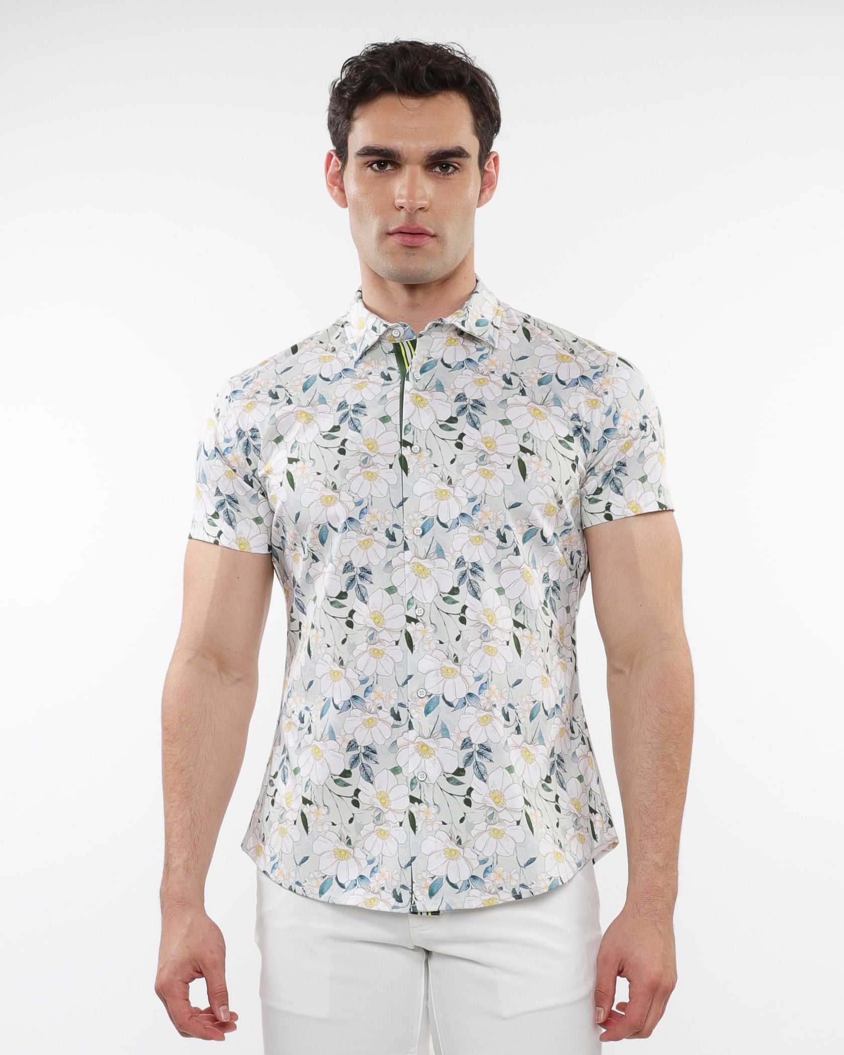A man wearing a white floral print stretch knit short-sleeved shirt with green and yellow accents