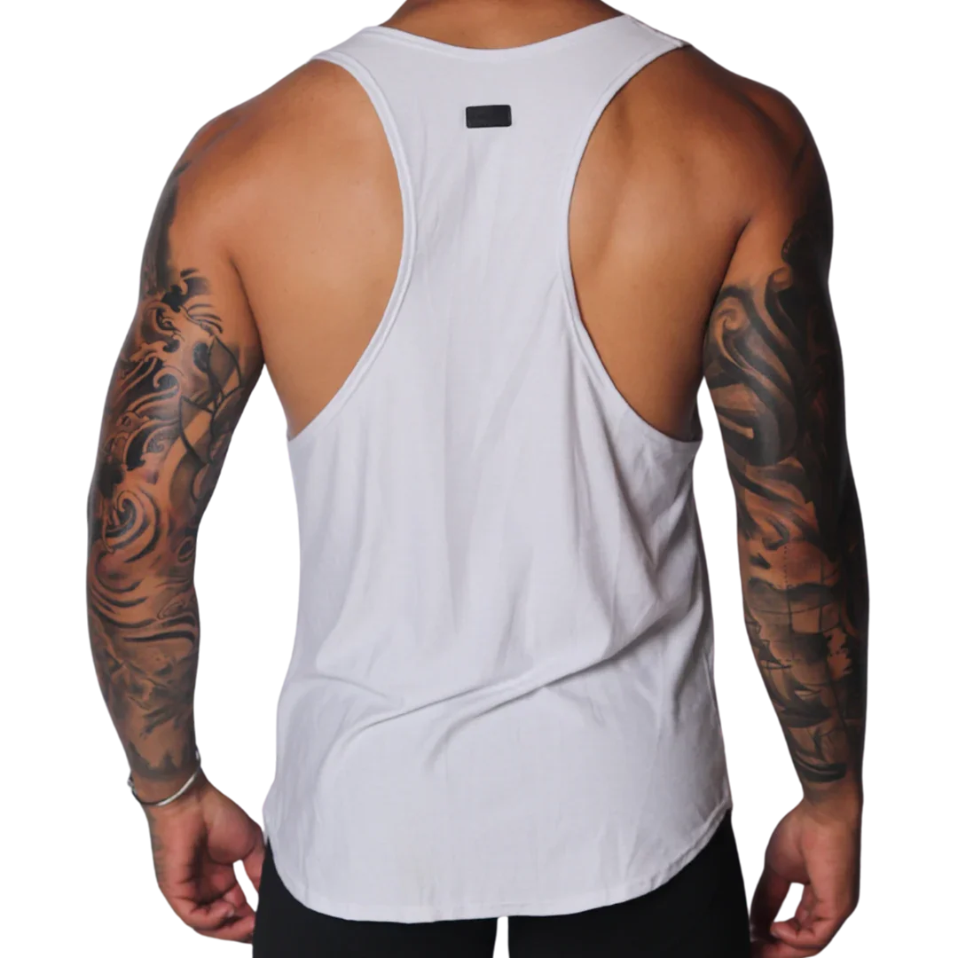 White racerback tank top with deep-cut sides, a curved hem, and a small black logo patch at the upper back.