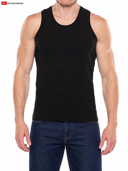 A muscular man wearing a black tank top from Go Softwear paired with blue jeans standing against a plain background