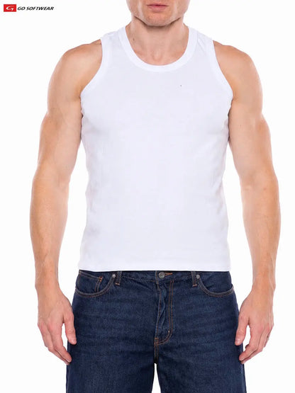 A model wearing a white tank top from Go Softwear paired with dark denim jeans showcasing a fitted style and muscular build