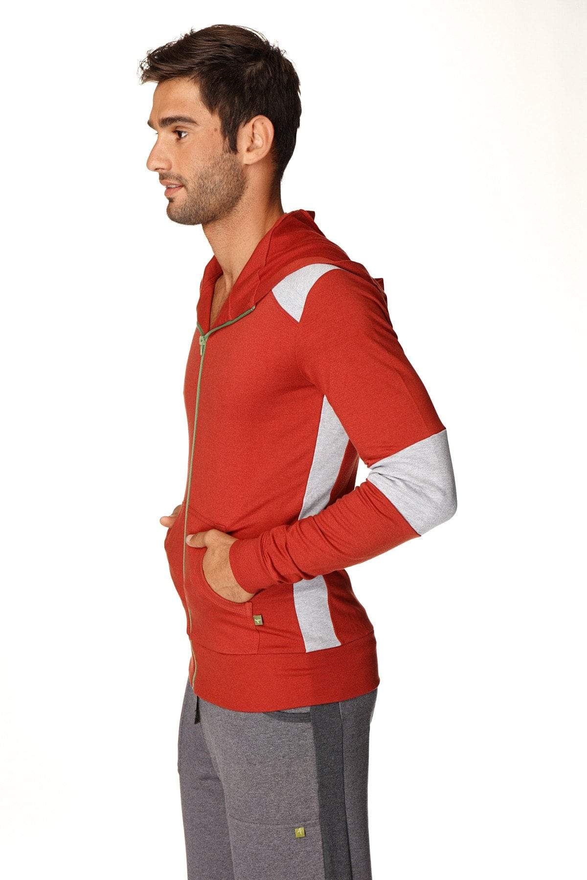 Form-fit crossover yoga track performance hoodie in cinnabar grey with red zip-up design, white shoulder panels, and gold zipper