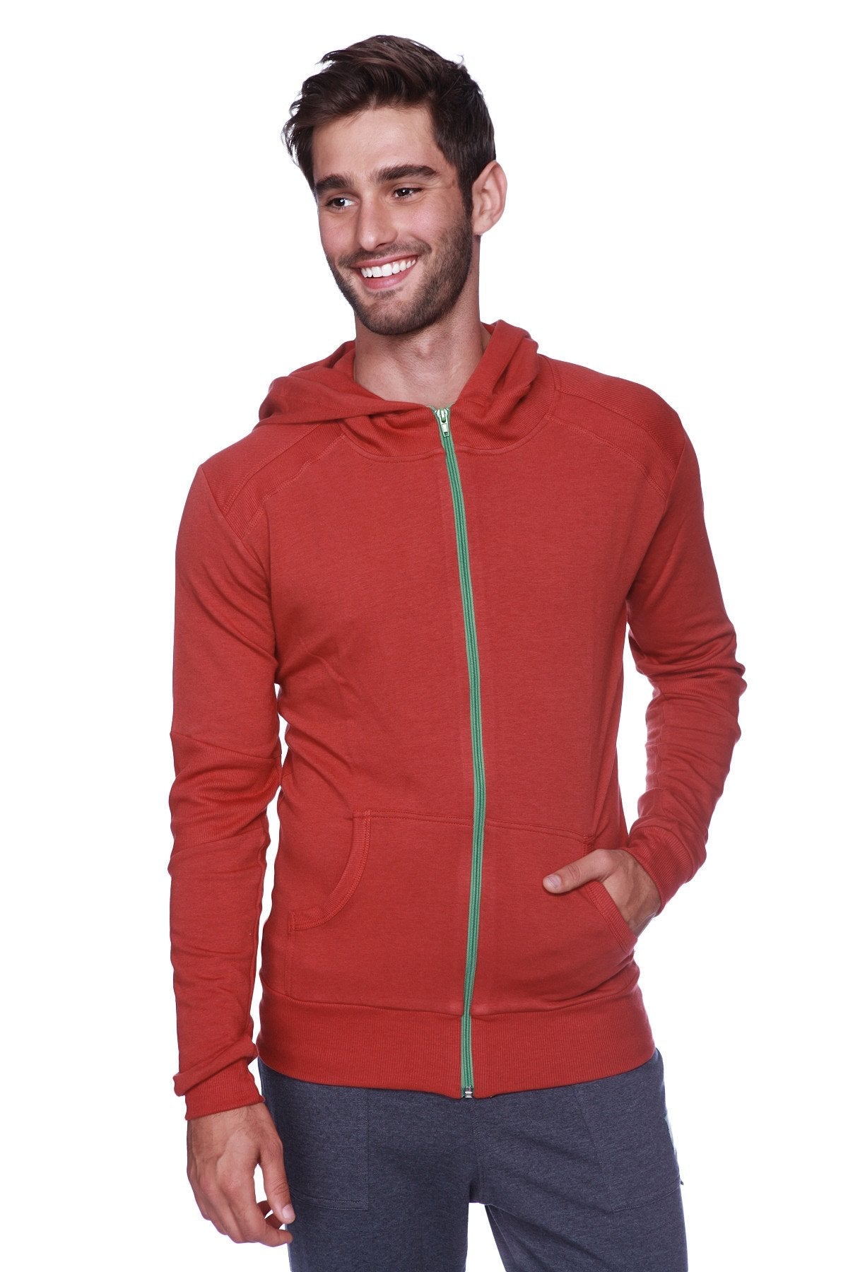 A solid cinnabar form-fit crossover yoga track performance hoodie in red with a green zipper and front pockets