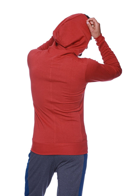 A form-fit cinnabar long-sleeved hooded sweatshirt with subtle seam detailing for yoga and track performance