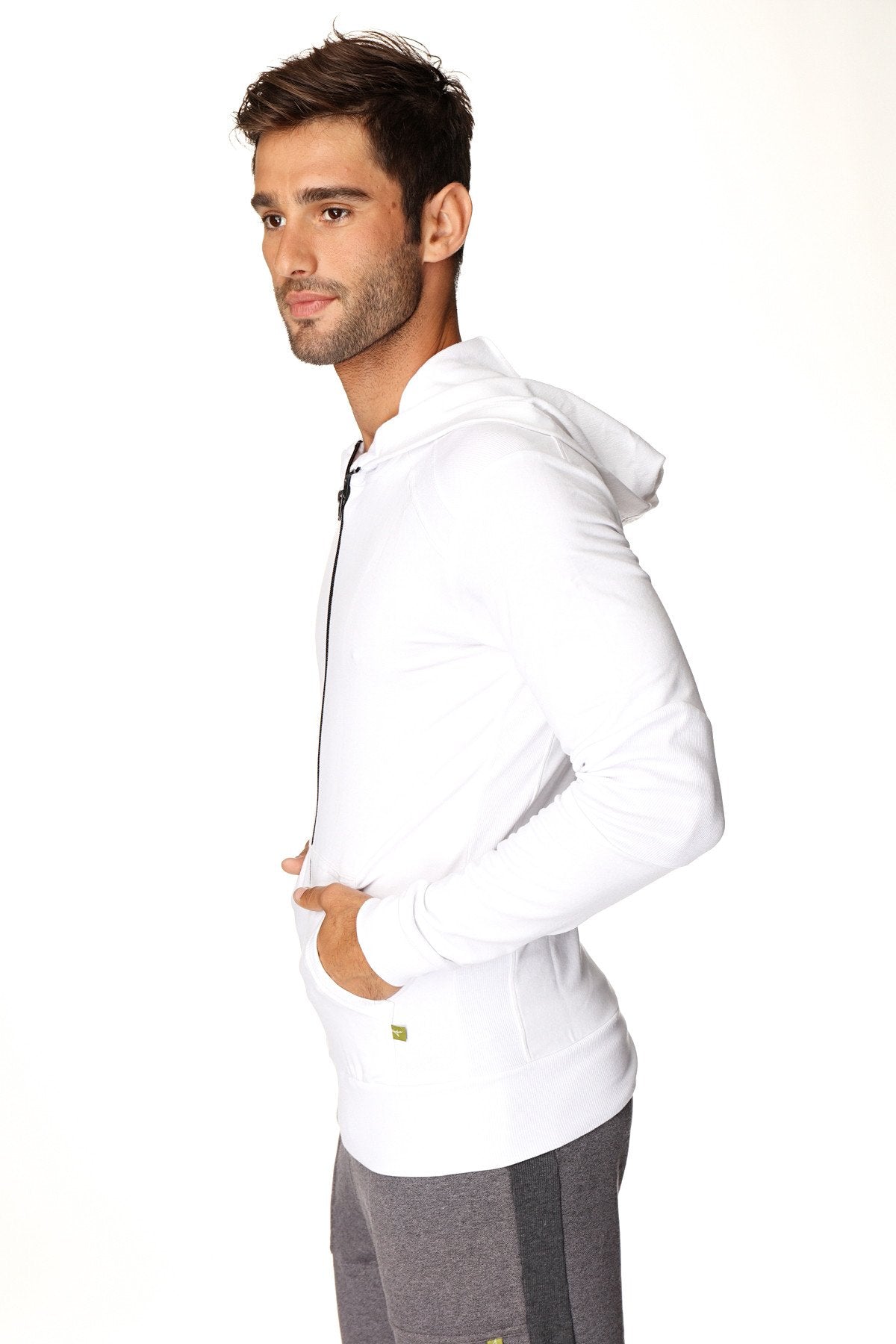 White long-sleeved form-fit crossover yoga track performance hoodie with black zipper and subtle green logo on lower left side