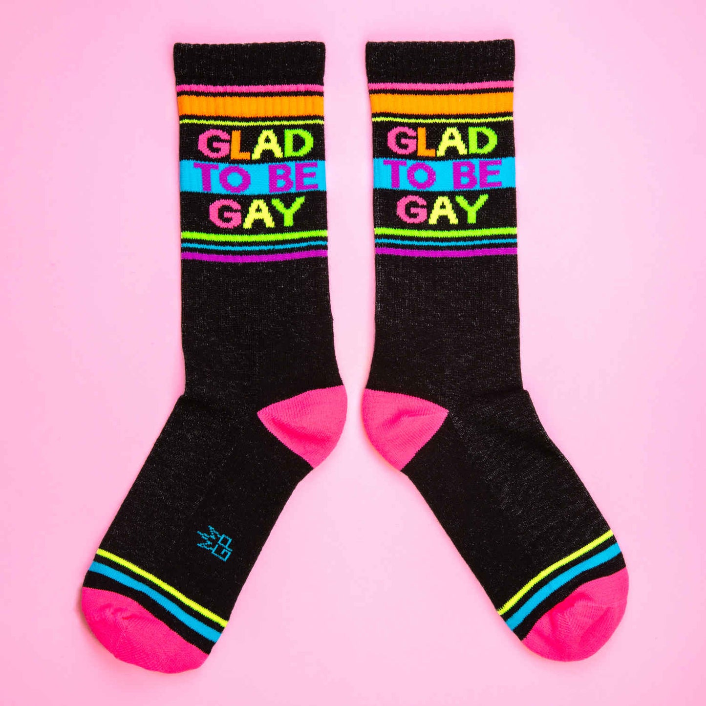 Glad to be gay crew socks with black base rainbow stripes and bold colorful lettering for pride wear